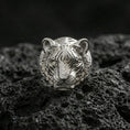 Load image into Gallery viewer, Polished silver tiger face ring on textured volcanic stone, macro focus on the tribal stripe engraving