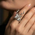 Load image into Gallery viewer, Polished silver stag head ring on a hand, close-up highlighting the sculpted fur lines and antler detail