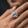 Load image into Gallery viewer, Polished silver Poseidon ring on hand, crowned god portrait detail visible, everyday luxury lifestyle shot
