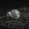 Load image into Gallery viewer, Octagon sterling silver Foo Dog signet ring in polished silver finish on volcanic rock, detailed guardian lion carving, close-up photo