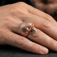 Load image into Gallery viewer, Cronus skull ring in a rose gold plated finish on finger, detailed numerology pattern across the skull, lifestyle wear photo