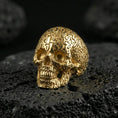 Load image into Gallery viewer, Numerology skull signet ring in a gold plated finish on volcanic rock, bold memento mori skull covered with engraved numbers, premium macro image