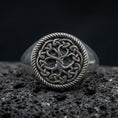 Load image into Gallery viewer, Sterling silver Yggdrasil Tree of Life ring in an oxidized finish on volcanic rock, Celtic knotwork circle with rope border, macro studio product shot