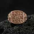 Load image into Gallery viewer, Jerusalem Cross signet ring in a rose gold plated finish on volcanic rock, medieval cross design with textured background, luxury studio close-up