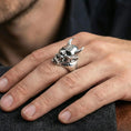 Load image into Gallery viewer, Oni skull ring in polished silver finish on finger, sharp fangs and demon mask carving, natural lifestyle wear shot