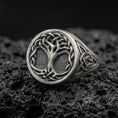 Load image into Gallery viewer, Sterling silver Celtic Yggdrasil Tree of Life ring in an oxidized finish on volcanic rock, braided branches and knotwork band, macro studio product shot