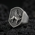 Load image into Gallery viewer, Sterling silver gryphon signet ring in an oxidized finish on volcanic rock, mythical griffin relief on shield-shaped face, macro studio product shot