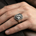 Load image into Gallery viewer, Sterling silver Anubis ring in an oxidized finish worn on finger, jackal god emblem and skull detail visible, lifestyle hand close-up