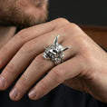 Load image into Gallery viewer, Oni demon ring in polished silver finish on finger, bold horned mask detail and textured band, clean lifestyle hand photo
