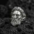 Load image into Gallery viewer, Polished silver Zeus ring featuring classical Greek god portrait and laurel wreath relief, centered close-up on dark volcanic stone