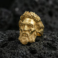 Load image into Gallery viewer, Gold plated Zeus signet ring with sculpted beard and laurel crown motif, premium studio macro shot on porous volcanic rock surface