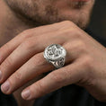 Load image into Gallery viewer, Polished silver griffon ring on finger highlighting detailed griffin relief and ornamental frame, clean lifestyle wear photo