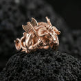 Load image into Gallery viewer, Rose gold plated Minotaur ring showcasing fierce bull-headed warrior and double axe motif, sharp close-up product photography on volcanic rock