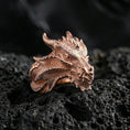 Load image into Gallery viewer, Rose gold plated dragon ring showcasing detailed scale engraving and sharp horned dragon features, crisp close-up product photography on volcanic rock