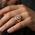 Load image into Gallery viewer, Rose gold plated Medusa signet ring on finger featuring snake hair portrait and textured background, refined mythology jewelry lifestyle wear shot