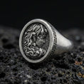 Load image into Gallery viewer, Detailed Medusa signet ring crafted in oxidized 925 sterling silver, snake hair portrait with Greek key border, macro product shot on textured volcanic rock background