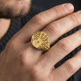 Load image into Gallery viewer, Gold plated handprint seal ring worn on finger, gothic statement jewelry with skull band and bold emblem, lifestyle macro