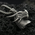 Load image into Gallery viewer, Oxidized sterling silver dragon pendant on textured volcanic rock, detailed scale pattern and horns, macro studio shot