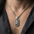 Load image into Gallery viewer, Oxidized sterling silver Chinese tiger pendant worn on neck on a braided chain, centered chest framing, moody lifestyle studio shot