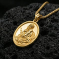 Load image into Gallery viewer, Gold plated Jesus Christ pendant on porous volcanic rock backdrop, devotional oval medal with detailed relief and antique styling, high-contrast lighting