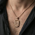 Load image into Gallery viewer, Rose gold plated St Christopher pendant worn on neck, detailed saint and child relief, clean lifestyle framing with dark shirt contrast