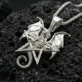 Load image into Gallery viewer, Polished silver dragon pentagram necklace on dark volcanic stone, crisp wing detail and geometric star outline, premium close-up composition