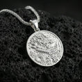 Load image into Gallery viewer, Polished silver Chinese dragon coin pendant necklace on dark volcanic stone, crisp scale relief and swirling cloud details, premium close-up composition