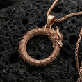 Load image into Gallery viewer, Rose gold plated ouroboros dragon circle pendant on volcanic stone surface, tail-biting dragon eternity necklace, sharp detail