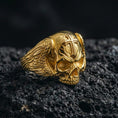 Load image into Gallery viewer, Gold plated skull ring with cross on dark volcanic rock, memento mori statement ring, premium studio macro photo