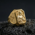 Load image into Gallery viewer, Gold plated Saint Francis signet ring on dark volcanic rock, detailed saint relief, cross side accent