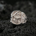 Load image into Gallery viewer, Polished silver Saint Michael signet ring on porous volcanic stone, archangel with sword engraving, cross side detail close-up