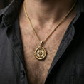 Load image into Gallery viewer, Gold plated dragon compass pendant worn on the neck, macro view highlighting the compass points and scaled border