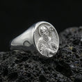 Load image into Gallery viewer, Polished silver Saint Benedict signet ring on porous volcanic stone, detailed saint engraving, religious signet ring
