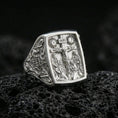 Load image into Gallery viewer, Polished silver INRI cross ring on porous volcanic stone, rectangular signet face with crucifixion scene, ornate side filigree