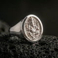 Load image into Gallery viewer, Polished silver Ganesha signet ring on porous volcanic stone, round face with engraved elephant god motif and smooth band