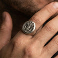 Load image into Gallery viewer, Oxidized 925 sterling silver multi-faced deity signet ring worn on finger, detailed relief face design in dark antiqued finish