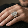Load image into Gallery viewer, Polished silver Saint Michael signet ring worn on finger, “Quis ut Deus” shield engraving and textured background