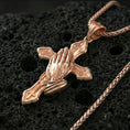 Load image into Gallery viewer, Rose gold plated praying hands cross pendant on textured volcanic rock, luxury close-up capturing the sculpted hands, rosary beads, and warm metallic glow
