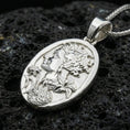 Load image into Gallery viewer, Polished silver Persephone pendant on porous volcanic stone, Greek goddess profile with pomegranate and floral relief necklace