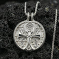 Load image into Gallery viewer, Polished silver ankh necklace on porous volcanic stone, Eye symbol medallion with detailed Egyptian-inspired relief and circular frame