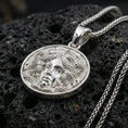 Load image into Gallery viewer, Polished silver medusa coin necklace on porous volcanic stone, detailed gorgon face medallion with crisp sculpting