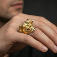 Load image into Gallery viewer, Gold plated horned skull statement ring worn on a finger, lifestyle image emphasizing bright plating tone and bold fantasy skull design