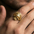 Load image into Gallery viewer, Gold plated laurel crown skull ring worn on a finger, lifestyle image emphasizing bright plating tone and striking gothic skull silhouette