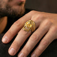 Load image into Gallery viewer, Gold plated baroque skull ring worn on a finger, lifestyle image emphasizing warm plating tone, intricate floral filigree and luxury gothic biker style