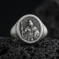 Load image into Gallery viewer, Oxidized sterling silver Spartan warrior signet ring with spear and shield relief, photographed on black volcanic rock in a dark macro studio