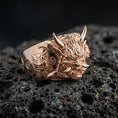 Load image into Gallery viewer, Rose gold plated Japanese demon mask ring with detailed Oni facial carving and side symbol engraving, macro image on volcanic rock
