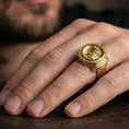 Load image into Gallery viewer, Gold plated Greek coin ring worn on a finger, close-up lifestyle image emphasizing the raised coin relief and braided border