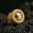 Load image into Gallery viewer, Gold plated Greek coin signet ring with raised warrior profile and braided rope border, macro product-only image on black volcanic rock