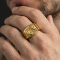 Load image into Gallery viewer, Gold plated Archangel Michael ring worn on a finger, close-up lifestyle image showing the raised battle artwork and bold signet shape