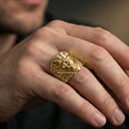 Load image into Gallery viewer, Gold plated devil head ring worn on a finger, close-up lifestyle image emphasizing the crossed swords motif and bold signet profile